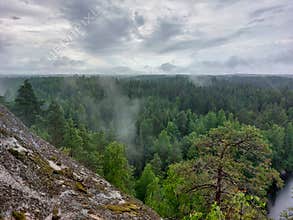 Fog over the lake, rocks and forest in the Repovesi National Park after the rain - view from Katajavuori Hill