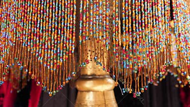 A Moroccan, Arabic brass lamp with colorful beaded strings. Handmade, crafted lamp design closeup.