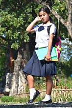 Female Student Wearing School Uniform Holding Books