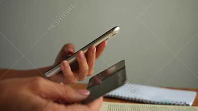 Close-up cropped shot of unrecognizable female customer buying online with credit card using smartphone and doing online