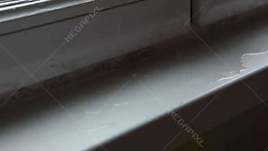 Close up of male hands wipe leaking moisture from damaged double-glazed windows with rag. Broken windowprane in rainy