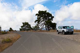 Vacation with a rental car. 4x4 SUV Jeep Renegade on asphalt road on Rhodes island, Greece