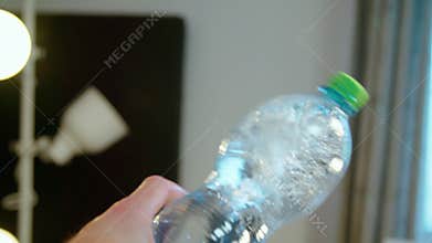 hand shaking mineral water bottle