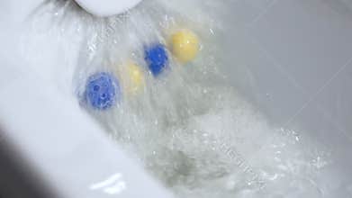 Top view flush toilet bowl with water. Scented balls for the toilet.
