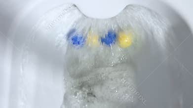 Top view flush toilet bowl with water. Scented balls for the toilet.