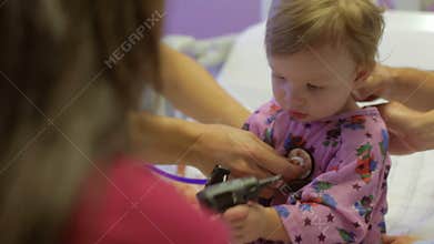 Family And Daughter With Staff In Pediatric Ward Of Hospital