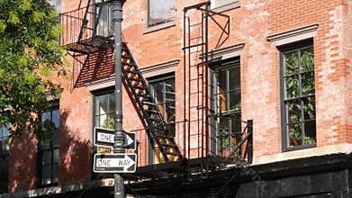 New York City building architecture, Manhattan. Residential house exterior. Red brick, fire escape.