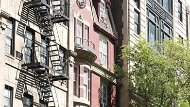 New York City building architecture, Manhattan. Residential house exterior. Red brick, fire escape.