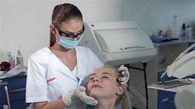 Skilled female dentist examines patient's teeth with precision dental tool