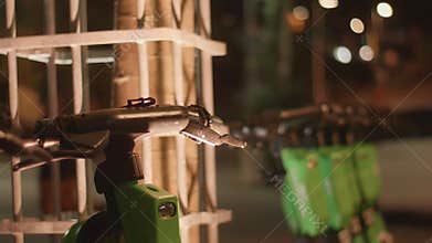row of scooters at night with blurred background of joggers and scooter commuters in a Parkland