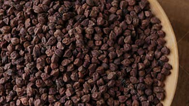 Raw Dark Brown Chickpeas (Kala Chana) on a rustic wooden table.