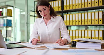 Angry woman hits papers on desk with palms after stressful day