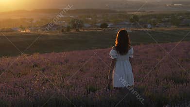 Lavender Woman Sunset: Girl in field during golden hour for relaxation and nature connection.