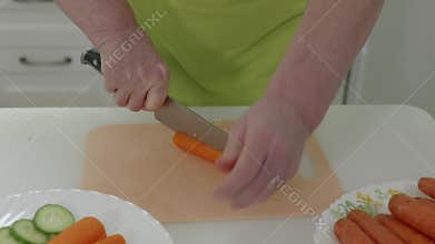 Chef slicing carrots on cutting board
