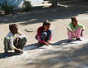 Young girls drawing with chalk at playground