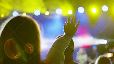 Worship or Concert Crowd with Raised Hand in Stage Lights at Outdoor Night Event