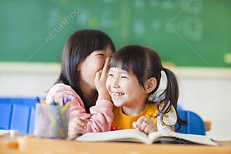 Cute little girls whisper to sister