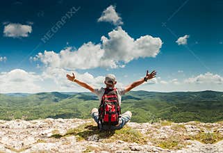 Man greeting nature on the top of mountain