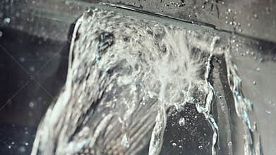 Jets of water are directed at the glass cleaning brush.