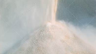 Machine pours pile of granite gravel