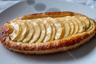 French fresh baked sweet puff pastry with fresh apple fruits in sirup in confectionery shop