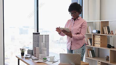 African American architect designing modern city concept with tablet