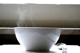 Steaming bowl of soup on table