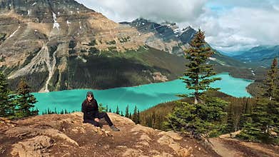 Woman poses at the breathtaking Peyto Lake viewpoint in Banff National Park, surrounded by mountains
