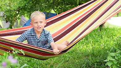 Little Boy with charming Smile in hammock