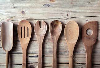 Row of assorted old wooden kitchen utensils