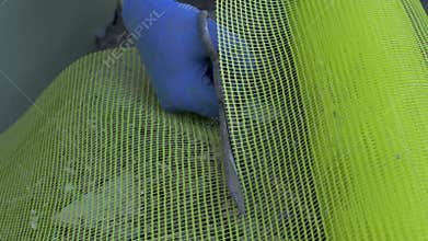 Worker's hand cut fiberglass grid