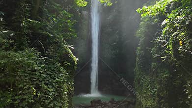 Drone shoot. Waterfall hidden in tropical rainforest jungle, falling water hitting water surface,