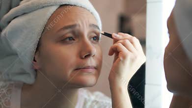procedure for plucking eyebrows in the bathroom at home in front of the mirror. Make-up. Eyebrow Makeup. Eyes