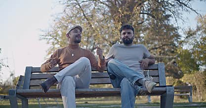 Two Friends Share a Lively Conversation and Express Various Emotions on a Park Bench