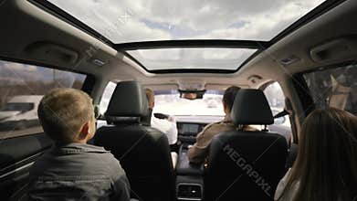 Family traveling by car, view from back seat