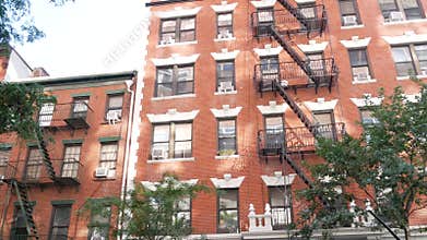 New York City building architecture, Manhattan. Residential house exterior. Red brick, fire escape.