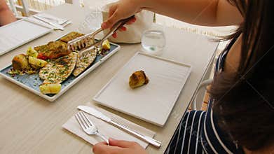 Woman Grabbing Grilled Swordfish For Lunch At Restaurant On The Beach