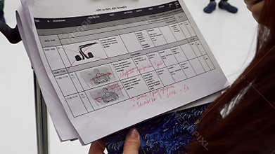 Woman producer holds clipboard with detailed storyboards