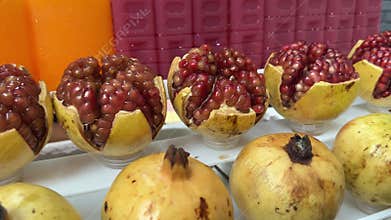 A display of colorful pomegranate and orange juices with the real fruits below the displays. It looks fresh and is ready