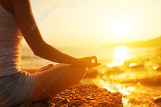 Hand of woman meditating in a yoga pose on beach