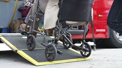 Close Up Of Disabled Person In Wheelchair Boarding Bus
