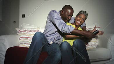 African American Couple On Sofa Arguing Over TV Remote