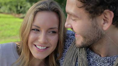 Couple Relaxing On Park Bench With Takeaway Coffee