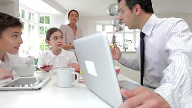 Family Using Digital Devices At Breakfast Table