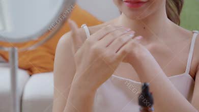 Closeup hands beautiful young woman applying lotion herb on hands looking mirror at home, beauty woman dropper serum for