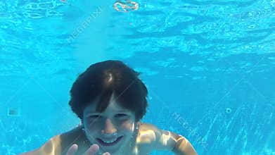 Boy Jumps Into Swimming Pool Then Swims Underwater To Camera