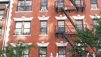 New York City building architecture, Manhattan. Residential house exterior. Red brick, fire escape.