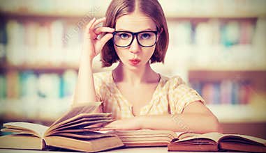 Funny girl student with glasses reading books