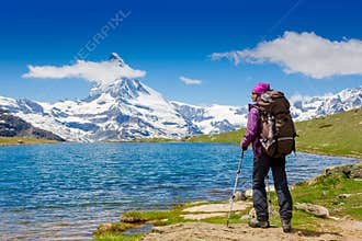 Young woman with backpack hiking in the mountains
