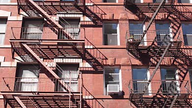 New York City building architecture, Manhattan. Residential house exterior. Red brick, fire escape.